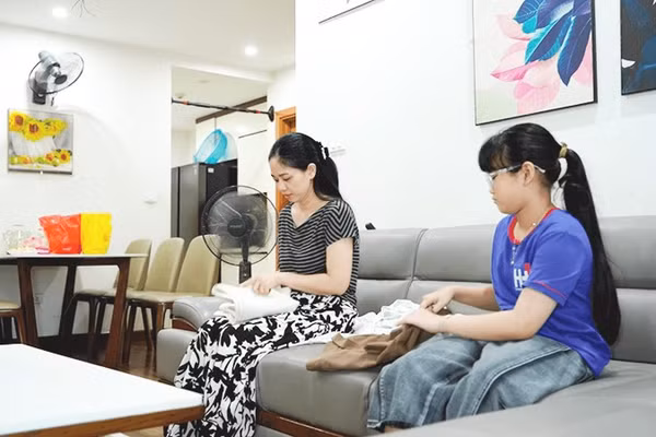 Chị Trương Thị Phượng và con gái chuẩn bị quần áo đem tặng.
