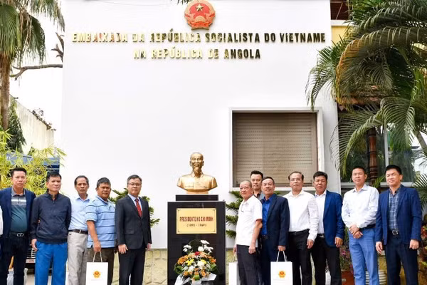 Đại sứ Dương Chính Chức cùng các cựu chiến binh chụp ảnh kỷ niệm bên Tượng đài Bác Hồ trong khuôn viên Đại sứ quán. (Ảnh: Đại sứ quán Việt Nam tại Angola cung cấp)