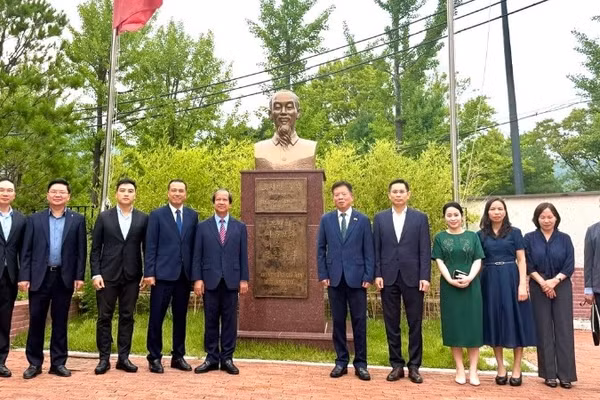 Đoàn công tác chụp ảnh cùng Đại sứ Vũ Hồ và cán bộ Đại sứ quán bên Tượng đài Chủ tịch Hồ Chí Minh trong khuôn viên Đại sứ quán. 