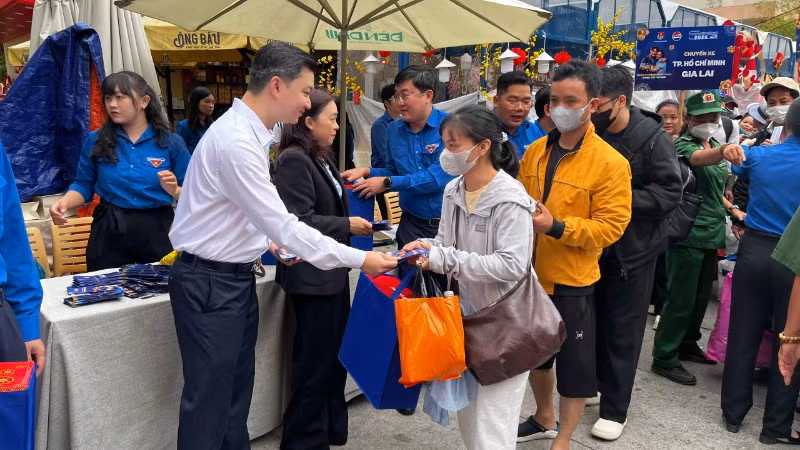 Đại diện Ban Tổ chức trao quà và lì xì cho người dân trước giờ khởi hành về quê đón Tết.