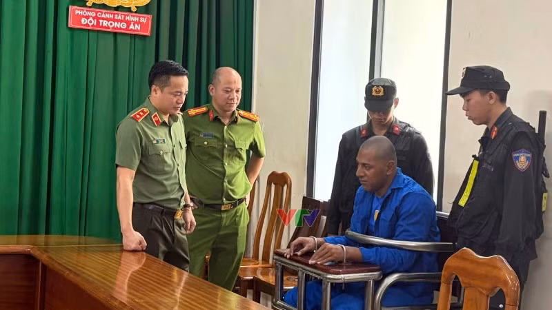 Một trong hai đối tượng (áo xanh) tại cơ quan chức năng. (Ảnh: Công an cung cấp)
