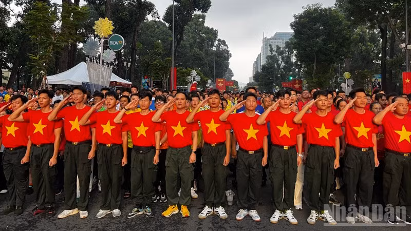 Nhân dân Thành phố Hồ Chí Minh chào cờ và hát Quốc ca tại Lễ Thượng cờ trực tuyến (Ảnh: QUANG QUÝ)
