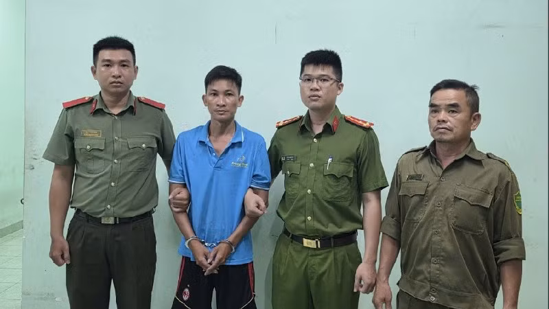 Đối tượng Bùi Trung Quốc (áo xanh) tại Cơ quan Công an. (Ảnh: Công an cung cấp)