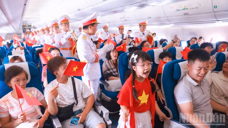 Các hành khách, hoa hậu Việt Nam và Đoàn Nghi lễ Quân đội cất cao tiếng hát. (Ảnh: TRUNG PHONG)