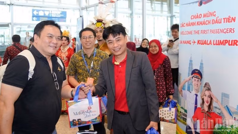 Ông Trần Hoàng Linh (phải), Giám đốc Văn phòng miền trung Vietjet đại diện hãng chào đón và tặng quà hành khách trên chuyến bay khai trương.