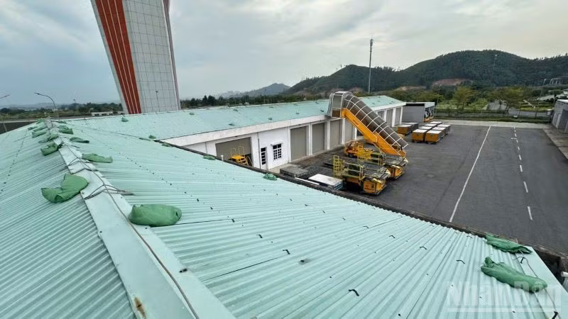 Gia cố bao cát tại mái nhà kho Cảng Hàng không quốc tế Vân Đồn.