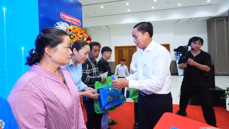 Đại diện Ban Tổ chức trao quà cho người dân có hoàn cảnh khó khăn tại chương trình.