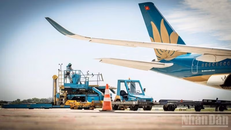 Các nhân viên phục vụ mặt đất tại sân đỗ vẫn miệt mài thực hiện các bước cuối cùng cho chuyến bay dưới nhiệt độ gần 80 độ C. (Ảnh: PHAN CÔNG)