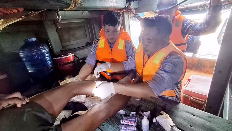 Cán bộ, chiến sĩ Cảnh sát biển tiến hành băng bó vết thương và cầm máu cho ngư dân gặp nạn. (Ảnh: Bộ Tư lệnh Vùng Cảnh sát biển 4)