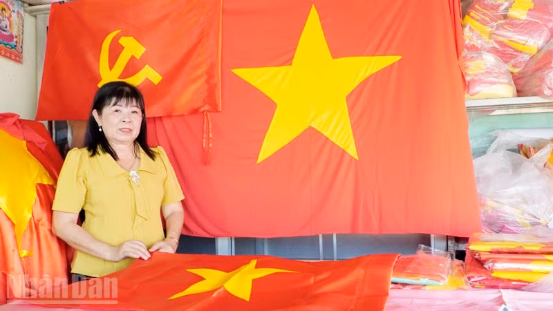 Bà Nguyễn Kiều Thu với những lá cờ Đảng, cờ Tổ quốc. 