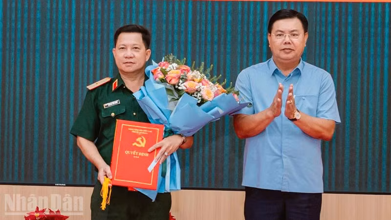 Đồng chí Nguyễn Tiến Hải, Ủy viên Trung ương Đảng, Bí thư Tỉnh ủy, Bí thư Đảng ủy Quân sự tỉnh An Giang trao quyết định, tặng hoa chúc mừng Thiếu tướng Nguyễn Văn Hùng. 