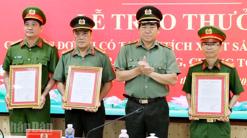 Thiếu tướng Nguyễn Văn Hận, Giám đốc Công an tỉnh An Giang trao quyết định khen thưởng cho các đơn vị. (Ảnh: TẤN AN).