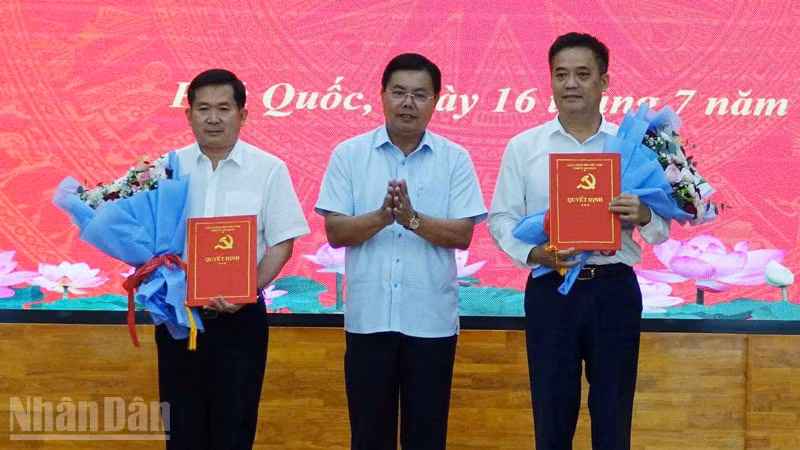 Ủy viên Trung ương Đảng, Bí thư Tỉnh ủy An Giang Nguyễn Tiến Hải trao quyết định và tặng hoa chúc mừng đồng chí Đinh Văn Nơi và đồng chí Lê Quốc Anh. 
