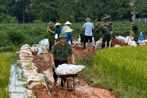 Công an xã Phúc Hòa tham gia đắp đê ngăn lũ. (Ảnh: ĐH)