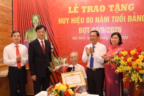 Đồng chí Nguyễn Duy Ngọc (thứ 2, trái sang) trao tặng Huy hiệu 80 năm tuổi Đảng cho đảng viên Nguyễn Thanh Mậu. (Ảnh: DL)