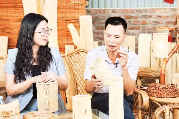 Anh Nguyễn Trọng Điểm giới thiệu chiếc đèn đu đủ với Phó Chủ tịch Ủy ban nhân dân xã Phú Nghĩa Trần Thị Thu Hằng.