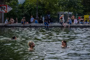 Người dân bơi trên kênh Saint-Martin để giải nhiệt trong đợt nắng nóng tại thủ đô Paris (Pháp). (Ảnh: THX/TTXVN phát)