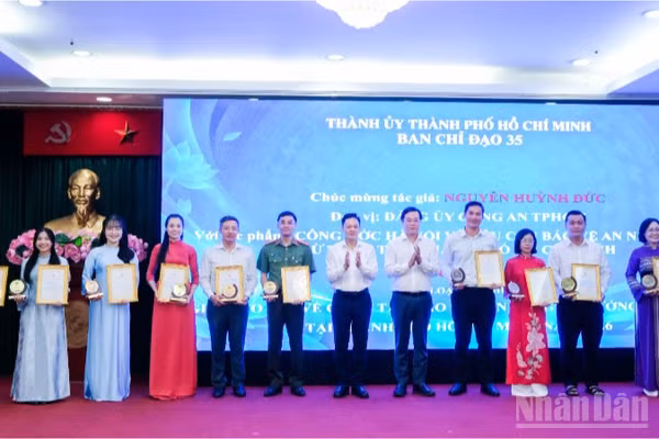 Đồng chí Lê Quốc Phong, Phó Bí thư Thường trực Thành ủy Thành phố Hồ Chí Minh (thứ 5 từ phải qua), đồng chí Nguyễn Huy Ngọc, Vụ trưởng Vụ Địa phương 3, Ban Tuyên giáo Trung ương trao giải cho các tác giả đoạt giải ở thể loại tạp chí. (Ảnh: THẾ ANH)