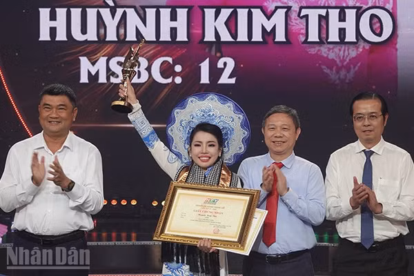 Trung tướng Lê Xuân Thế (bìa trái), Ủy viên Trung ương Đảng, Ủy viên Quân ủy Trung ương, Phó Bí thư Đảng ủy, Tư lệnh Quân khu 7; Trưởng Ban Tuyên giáo Thành ủy Dương Anh Đức và Tổng Giám đốc Cơ quan Báo và Phát thanh, Truyền hình Thành phố Lê Văn Minh trao Chuông Vàng cho thí sinh Huỳnh Kim Tho. (Ảnh: LINH BẢO)