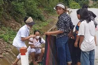 Hai cán bộ Trạm Y tế xã Mường Típ đỡ đẻ cho sản phụ trên đường. (Ảnh: NGỌC MAI)