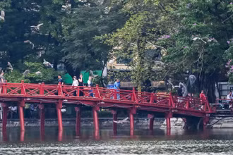 Nhiều du khách dừng chân bên hồ để ngắm nhìn và ghi lại khoảnh khắc thiên nhiên hòa quyện với nhịp sống đô thị hiện đại.