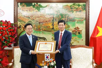 Thứ trưởng Hồ An Phong trao Bằng khen cho ông Lý Xương Căn, Đại sứ Du lịch Việt Nam tại Hàn Quốc. (Ảnh: TRẦN HUẤN)