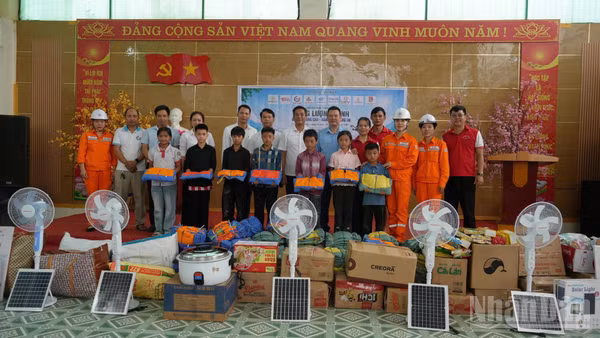 Đại diện Công ty Điện lực Lào Cai cùng chính quyền địa phương và các nhà tài trợ trao học bổng cho học sinh có hoàn cảnh khó khăn tại xã Nậm Xé. (Ảnh: Công ty Điện lực Lào Cai)