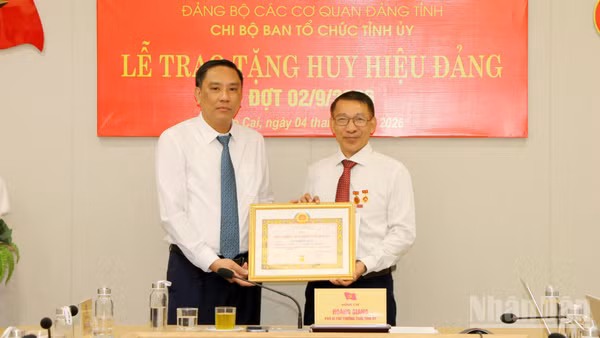 Phó Bí thư Thường trực Tỉnh ủy, Chủ tịch Hội đồng nhân dân tỉnh Lào Cai Hoàng Giang trao Huy hiệu 35 năm tuổi Đảng cho đồng chí Ngô Hữu Quý. (Ảnh: TÂM THỜI)