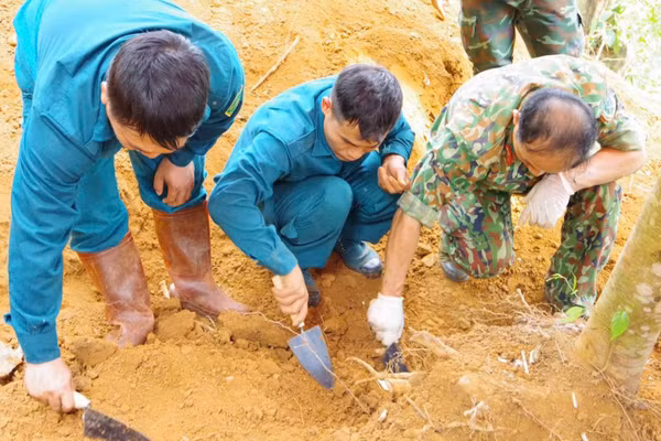 Lực lượng chức năng khai quật, tìm kiếm hài cốt liệt sĩ Lê Tước. (Ảnh: DUY ĐỨC)
