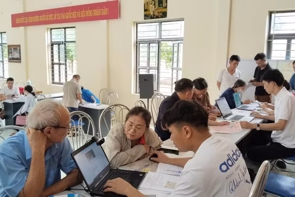 Cán bộ thôn Hồng Kỳ, xã Trung Giã (Hà Nội) hướng dẫn người dân cách sử dụng ứng dụng eTax Mobile, iHanoi và khai báo làm sạch dữ liệu đất đai. (Ảnh: LÊ TRƯỜNG) 