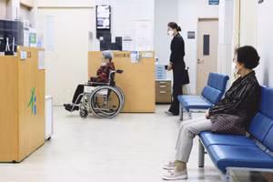 Công dân có thể thuê người cùng đi khám bệnh. Ảnh: REUTERS