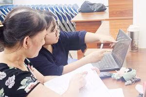 Hướng dẫn người dân cập nhật dữ liệu đất đai tại cụm dân cư. Ảnh: NGUYỆT ANH