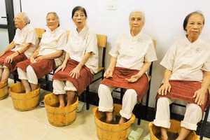 Các cụ cao tuổi được ngâm chân thảo dược trong ngày khai trương. Ảnh: THANH HÀ