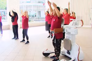 Ông Leow Cher Hwa tham gia lớp học Zumba với sự hỗ trợ trực tiếp từ robot hỗ trợ vận động. Ảnh: CNA