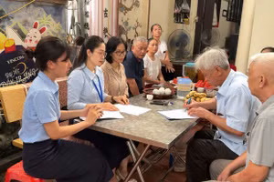 Các cán bộ Điểm hỗ trợ dịch vụ công số Kiến Hưng hỗ trợ người cao tuổi tại nhà. (Ảnh Trung tâm Phục vụ hành chính công Hà Nội)