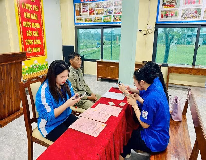 Đoàn viên thanh niên xã Cẩm Bình, tỉnh Hà Tĩnh hướng dẫn người dân làm hồ sơ trực tuyến.