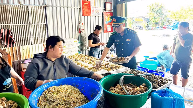 Cán bộ, chiến sĩ Đồn Biên phòng Xuân Đài cùng các thành viên Câu lạc bộ Hạnh Nguyện chuẩn bị các suất cơm trao tặng người dân khó khăn trên địa bàn.