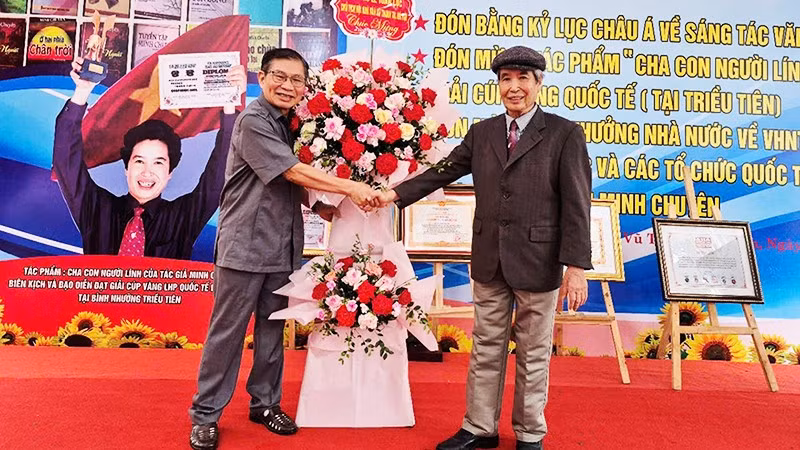 Nhà thơ Lê Tuấn Lộc chúc mừng nhà thơ Minh Chuyên (bên phải) trong ngày vui.