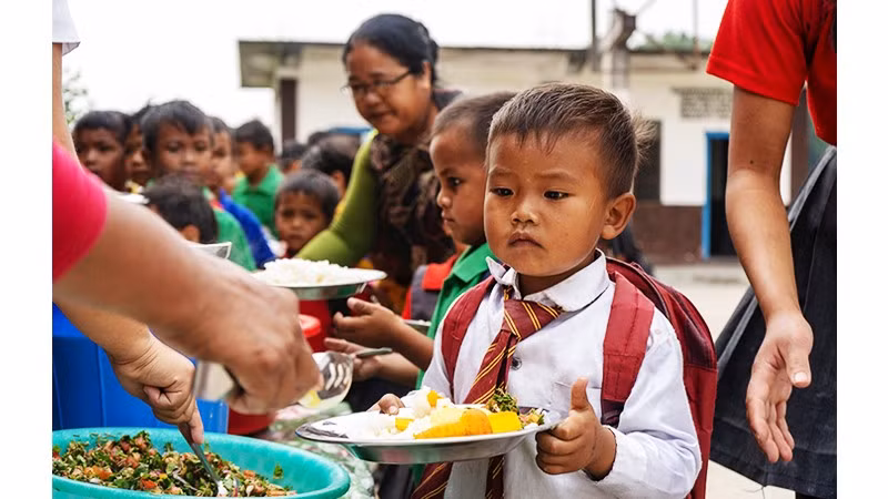 Học sinh nhận khẩu phần ăn trưa tại một trường ở đông bắc Ấn Độ. Ảnh: NESFAS