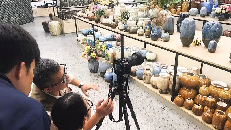 Nghệ sĩ nhiếp ảnh Lê Bích bồi dưỡng cho nhân viên Bảo tàng gốm Bát Tràng kỹ năng chụp ảnh quảng bá sản phẩm của làng nghề. Ảnh: HOÀNG HOA