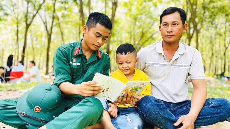 Binh nhì Võ Lê Phúc Thịnh, chiến sĩ Đại đội 7, Tiểu đoàn 2, Trung đoàn 4, Sư đoàn 5, Quân khu 7 bên những trang sách cùng gia đình trong buổi thăm thân cuối tuần.
