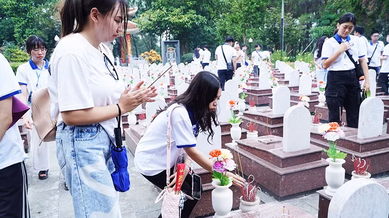 Thanh niên kiều bào thắp hương tưởng nhớ các anh hùng liệt sĩ tại Nghĩa trang Trường Sơn. Ảnh: NVNONN