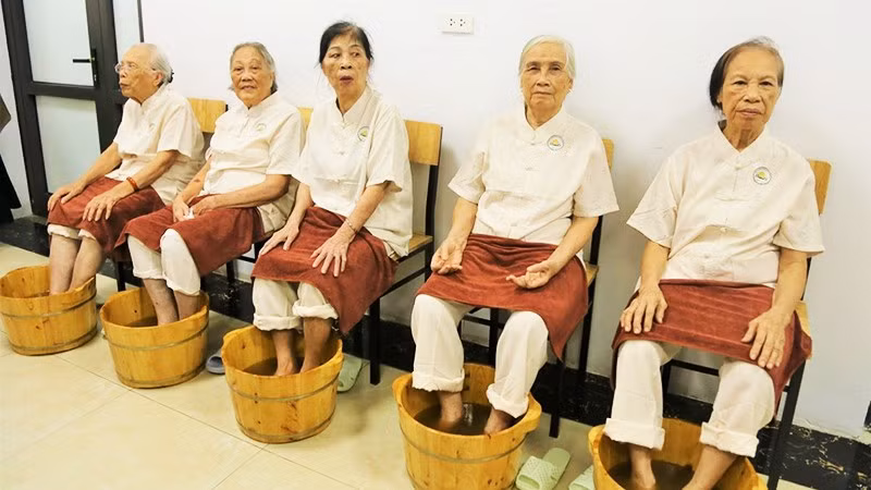 Các cụ cao tuổi được ngâm chân thảo dược trong ngày khai trương. Ảnh: THANH HÀ