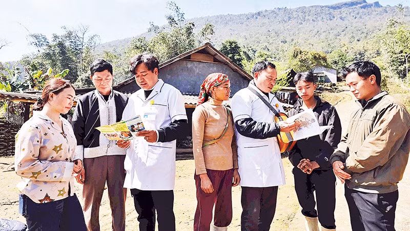Bác sĩ cùng nhân viên y tế thôn, bản tuyên truyền kiến thức về sức khỏe sinh sản tới đồng bào dân tộc vùng biên giới Lào Cai. Ảnh: TTXVN