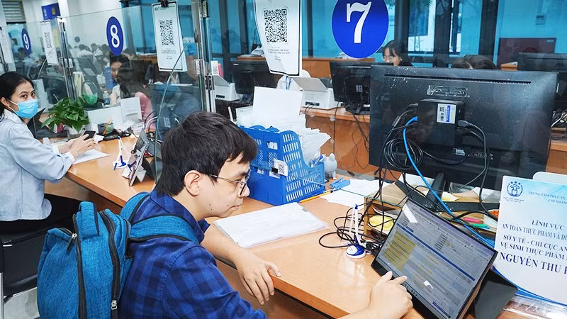 Người dân làm thủ tục tại trung tâm phục vụ hành chính công. Ảnh: NAM HẢI