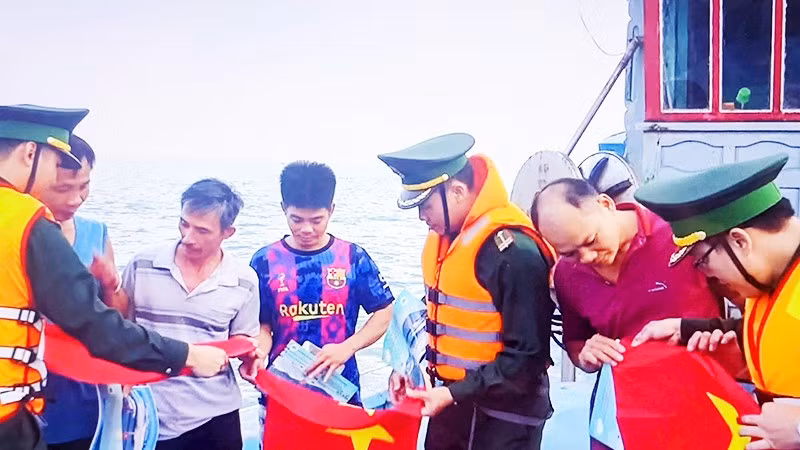 Cán bộ, chiến sĩ Hải đoàn 48 và Bộ Tư lệnh Vùng Cảnh sát biển 2 tặng cờ Tổ quốc cho ngư dân.