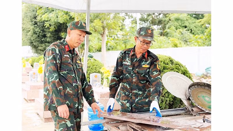 Trung tá Ngọc (bên phải) cùng đồng đội thao tác với chiếc máy mòi đá do anh sáng chế.