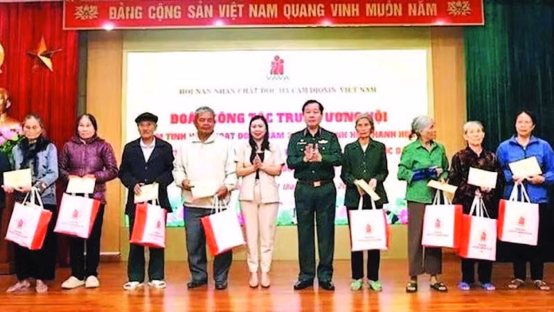 Đại diện Mặt trận Tổ quốc Việt Nam và Hội Nạn nhân chất độc da cam/dioxin trao quà tặng các gia đình bị ảnh hưởng bởi thiên tai. (Ảnh MAI LUẬN)