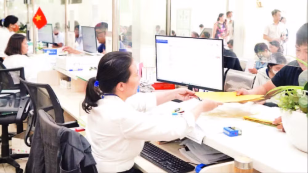 Người dân làm thủ tục hành chính tại Ủy ban nhân dân quận Bình Tân trước thời điểm thực hiện mô hình chính quyền địa phương hai cấp. (Ảnh THẾ ANH)