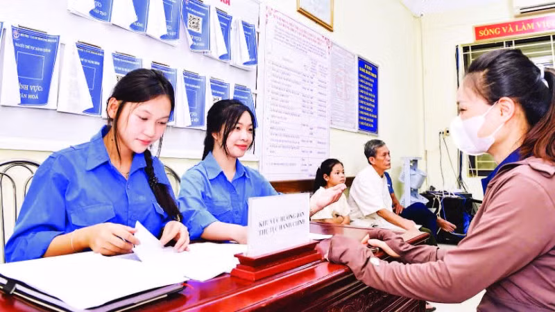 Đoàn viên, thanh niên tình nguyện hỗ trợ người dân xã Minh Châu làm thủ tục hành chính công tại trụ sở xã.